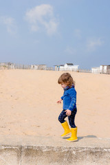cute little girl doing balance exercises on the beach