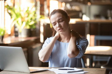 Tired girl massaging neck suffering from painful feeling