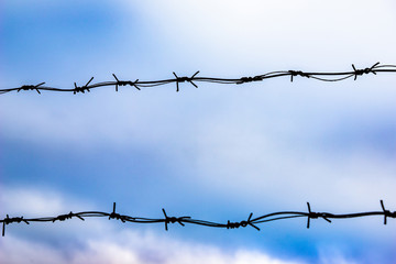 Barbed wire against the blue sky