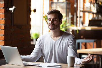 Calm male sit in cafe meditating controlling emotions