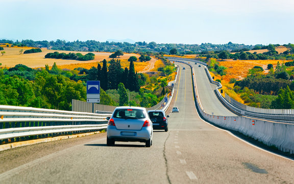 Car on the road at in Sardinia Island in Italy summer. Transport driving on the highway of Europe. View on motorway. Olbia province. Mixed media.