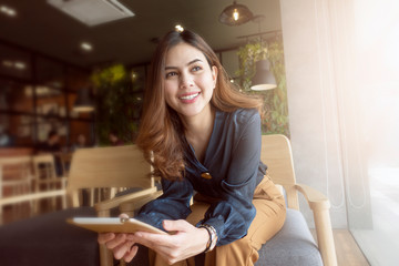 Beautiful woman is working with tablet in coffee shop