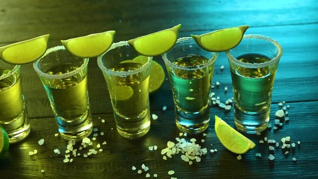 glasses with tequila and salt are on a bar