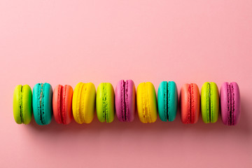 Macaroons dessert on pink background. Copy space. Top view.