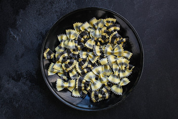 pasta farfalle cuttlefish ink (healthy eating, black multi-colored) menu concept. food background. top view. copy space