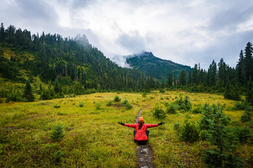 A female hiker sits on a trail and takes in the mountain scene © Forest2Sea