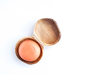 Ecological papaya soap in a wooden soap dish on a white background.