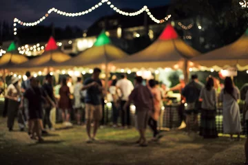 Foto op Canvas Blurred motion people walk in the food festival at night with decorative bokeh light in background © Phichat