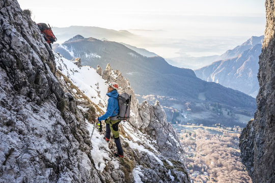Hiker climbing up rocky mountain