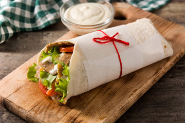 Doner kebab or shawarma sandwich on wooden table. 