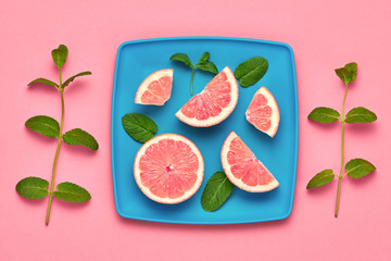 Orange fresh fruit with green mint leaves on plate. Healthy vegan food organic Concept. Creative citrus Flat lay. Trendy fashion Style. Minimal Art. Summer pink bright Color.