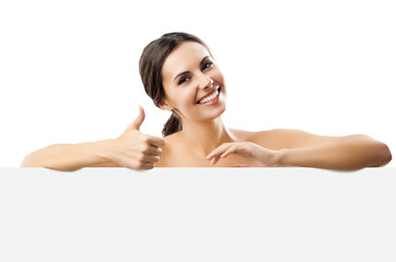 Happy smiling beautiful brunette woman showing blank signboard with copy space for some slogan or...