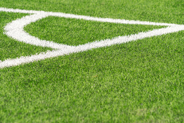 Green artificial grass turf soccer football field backgrond with white corner line boundary. Top view