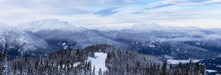 Fototapeta na wymiar Whistler, British Columbia, Canada. Beautiful Panoramic View of the Canadian Snow Covered Mountain Landscape during a cloudy and colorful winter sunset.