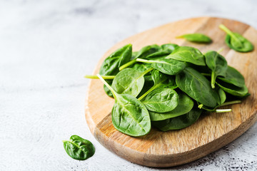 Raw fresh spinach leaves on a stone background