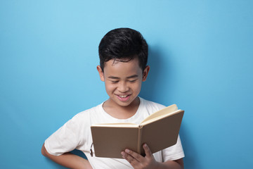 Obraz premium Asian boy smiling happily when reading a book