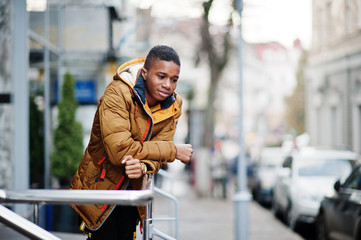 Fototapeta premium African man wear on orange jacket at cold weather posed outdoor.
