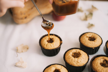 The baker creates cupcakes in molds. Filling biscuits with homemade liquid caramel. Making homemade muffins