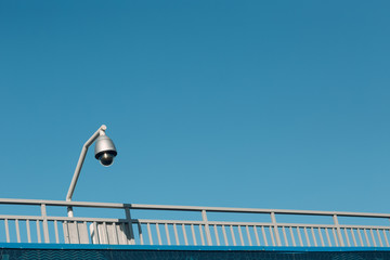 Obraz premium Surveillance camera on blue sky background