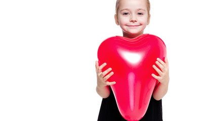 Little girl in a black elegant dress holding a red balloon in the shape of a heart on a white background