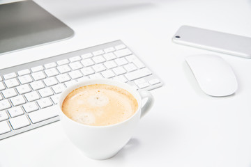 A cup of coffee on the work desk. Concept of rest, breaks in office work. A cup of coffee on the background of the keyboard, computer monitor mouse.