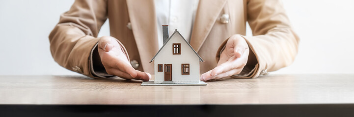 House model with agent asking costumer for contract to buy, get insurance or loan real estate or property.