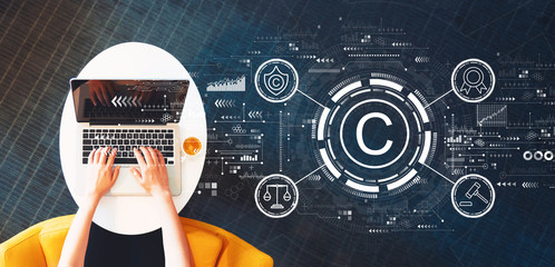 Copyright concept with person using a laptop on a white table