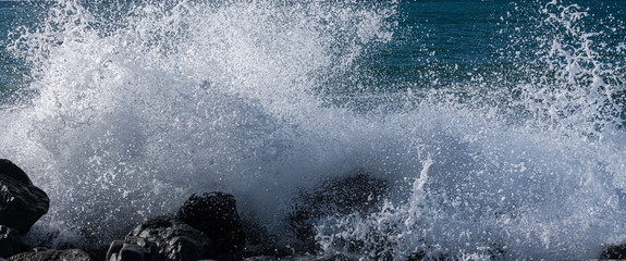 Blue waves crashing on a rocky shore