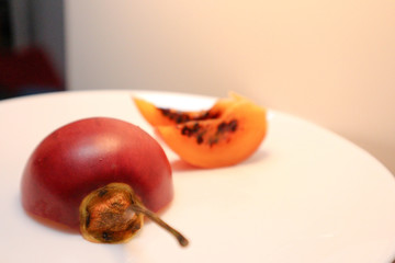 Ripe tamarillo in a section. Tamarillo on a white plate.