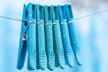 Blue clothespins on a rope. Laundry on the street. Blur background.
