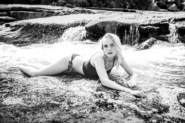 Young blonde in water at a waterfall