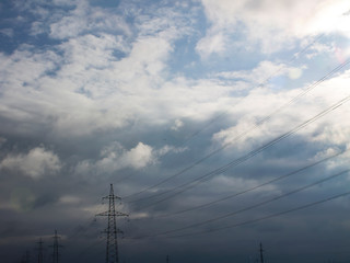 High-voltage line of electric wires against a background of dark thunderclouds.