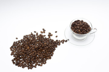 Scattered coffee beans in a glass cup, coffee concept