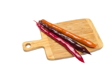 Churchkhela on a wooden board isolated on white background, ancient Georgian national sweetness