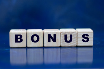concept word bonus on wooden cubes on a blue background