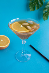 Aperol spritz cocktail in martini glass on the tropical background. Location vertical. Copy space.