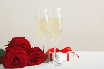 Champagne, flowers and gifts on the table. Valentine's day background.