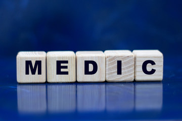 concept of the word medic on wooden cubes on a blue background
