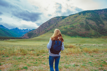 Fototapeta premium a beautiful girl stands against the background of mountains