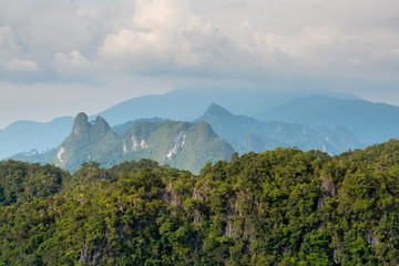 Beautiful view of the rocky hills covered with rainforest in the clouds