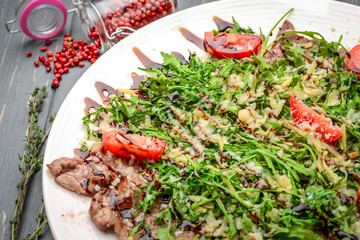 grilled meat sliced in thin slices with arugula
