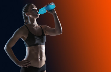 Fototapeta na wymiar Young girl drinking water of bottle after training. Fitness and healthy lifestyle concept.