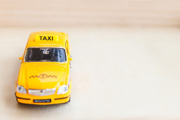 Simply design yellow vintage retro toy car Taxi Cab model on wooden background. Automobile and...