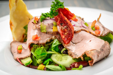 Salad leaves with sliced roast beef and sun-dried cherry tomatoes
