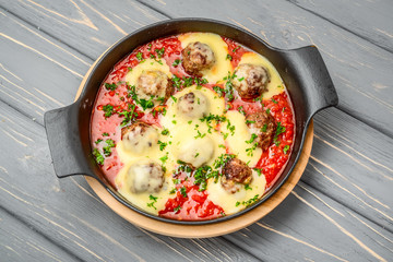 beef meatballs with tomato sauce and parmesan cheese in pan