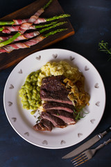 Grilled fillet beef steak with mashed potato, peas and fried onion. View from above, top view