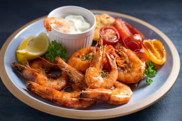 Shrimps or prawns with vegetables, garlic and sauce on plate