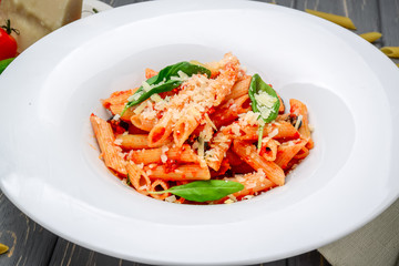 Penne pasta with shrimp and mussels, tomato sauce, basil and grated parmesan cheese