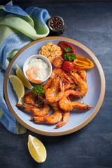 Shrimps or prawns with vegetables, garlic and sauce on plate. Overhead, top view