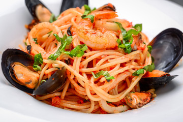 pasta with shrimp and mussels, tomato sauce, basil and grated parmesan cheese